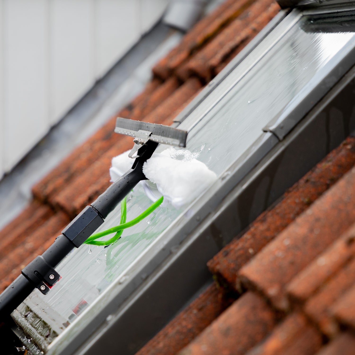 Using the washer of the washer-wiper set to clean a skylight