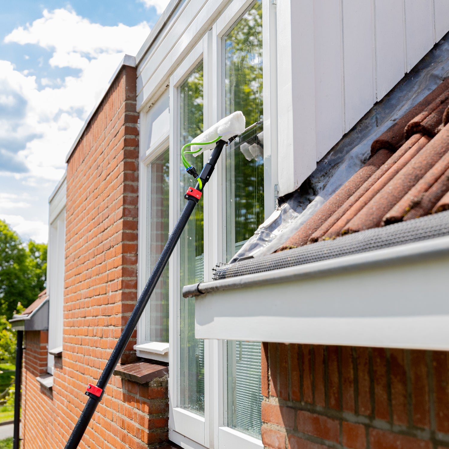 Using the washer-wiper set to clean a high window