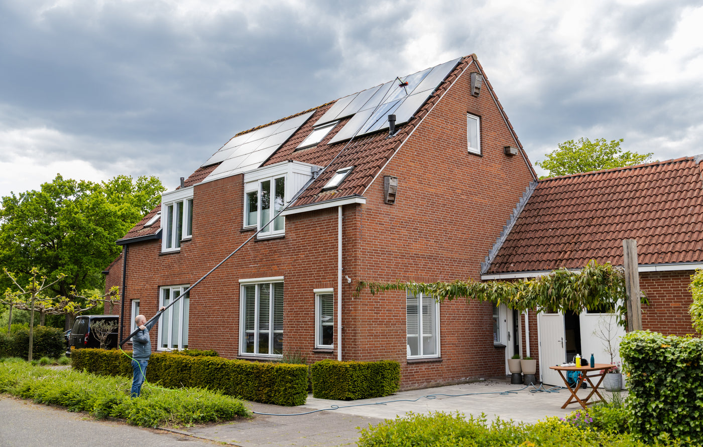 Wide shot of cleaning solar panels using a standard brush