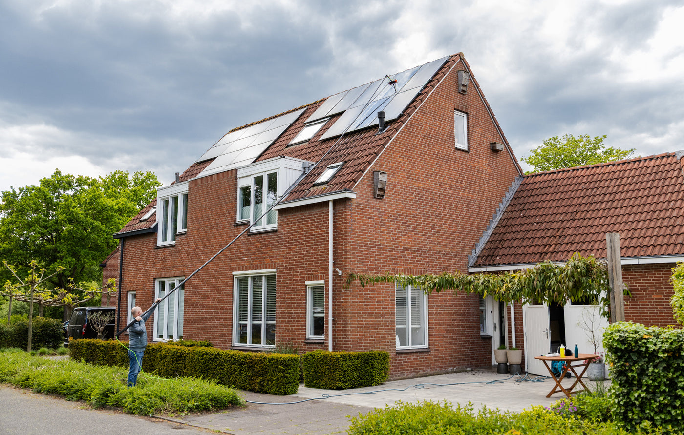 Wide shot of cleaning solar panels using a standard brush