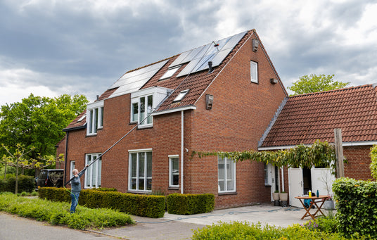 Wide shot of cleaning solar panels using a standard brush