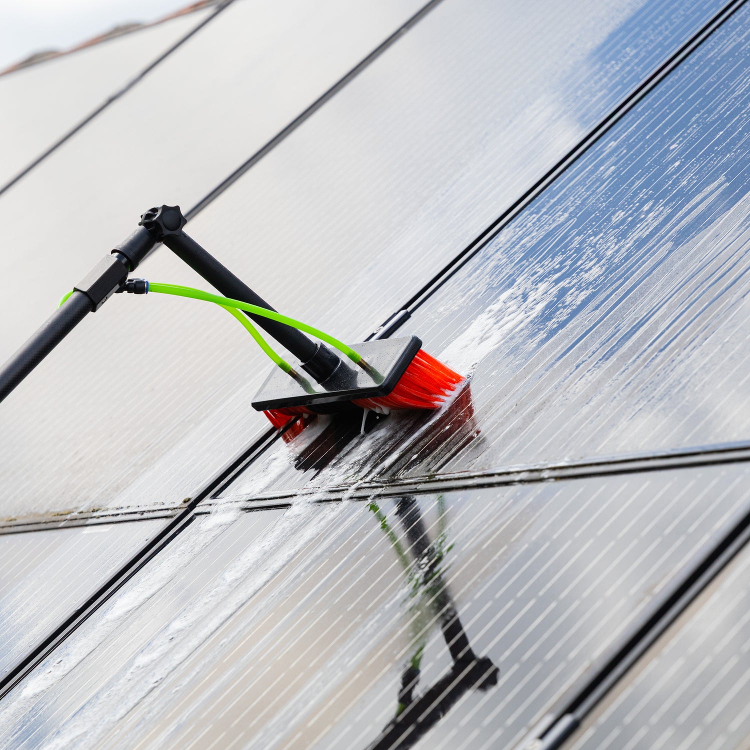 A close up of cleaning solar panels using the standard brush