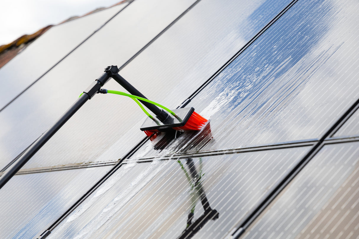 A close up of cleaning solar panels using the standard brush