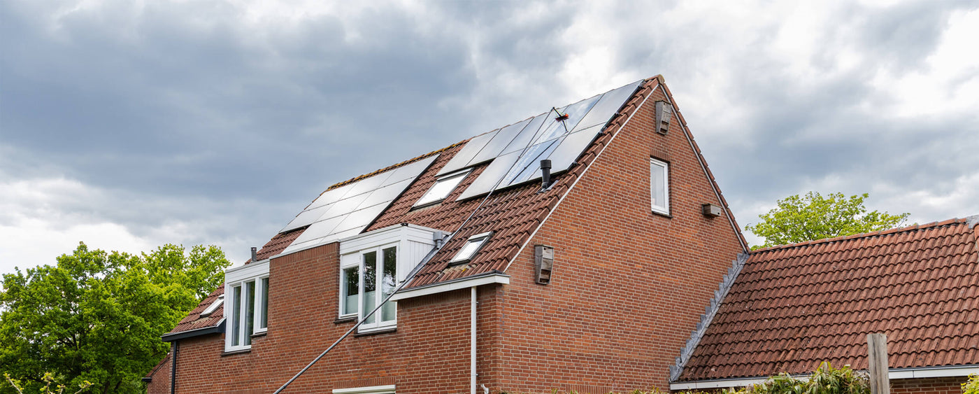 Wide shot of cleaning solar panels using a standard brush