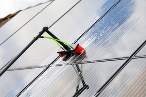 A close up of cleaning solar panels using the standard brush